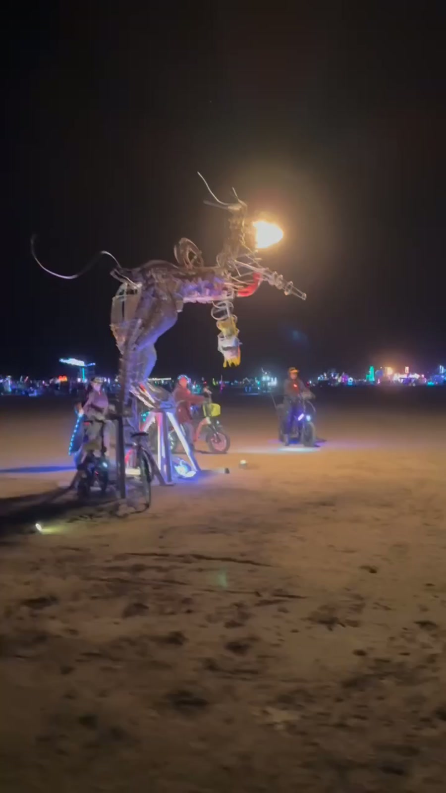 Navagunjara Reborn at night with flame effects burning at its head, e-bikes circling below.